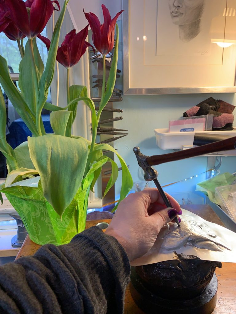 Hammering an Eastern repousse neckpiece based on the tulips