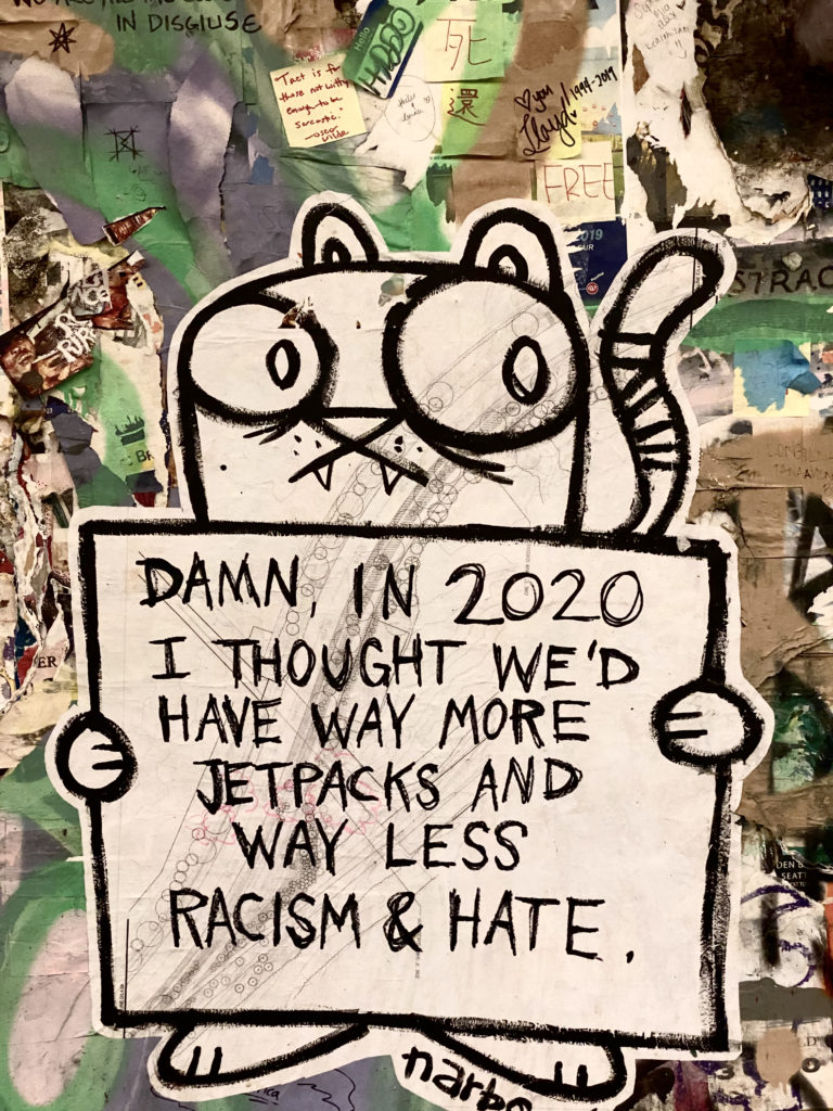 Graffiti in Seattle near Pikes Market that says "Damn, in 2020 I thought there wold be way more jetpacks and way less racism and hate," photo by Victoria Lansford