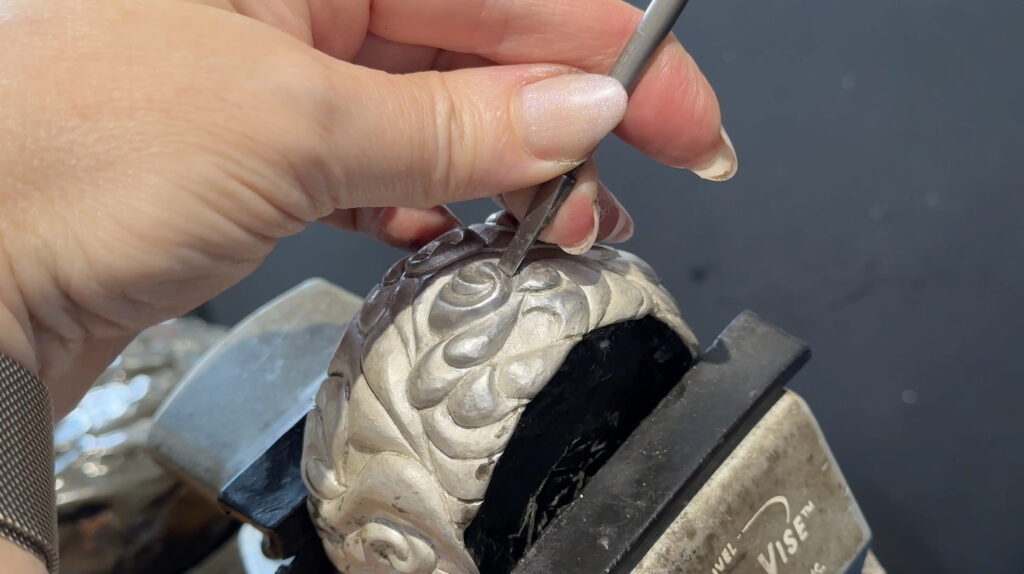Beginning the chasing process to refine shapes on Eastern repousse cuff bracelet