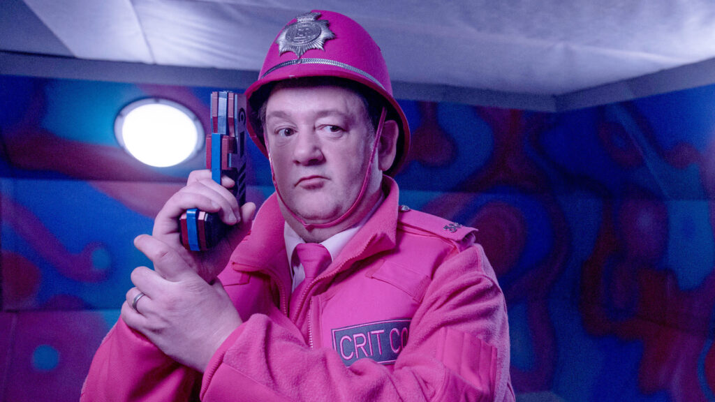 Jonny Vegas as the pepto-pink clad Criti Cop