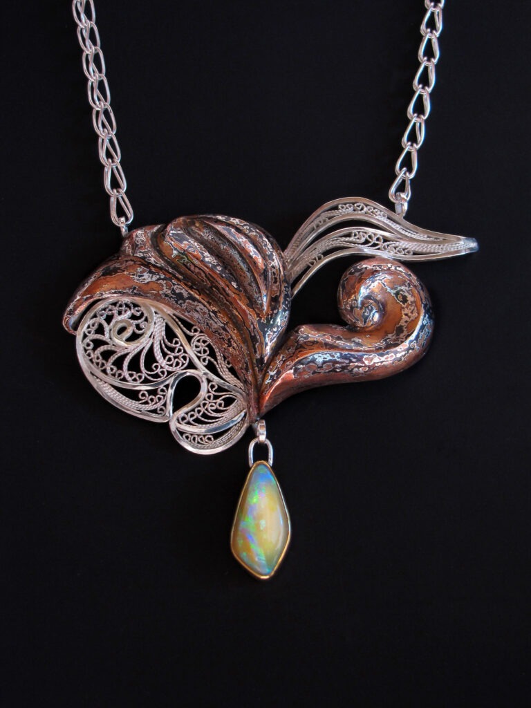 Passion Made Visible
Bottom left
Russian filigree and Eastern repoussé
patterned mokume gane pendant on
a Roman chain, 2011
Sterling, fine silver, copper, shibuichi,
22k gold, Koroit opal
2.5 x 3 x 0.375 in, 18 in. chain