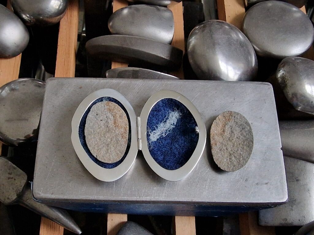 Pebble Box by Rauni Higson, an example of metalwork as taught in the course Mirrored Forms co-taught with Victoria Lansford - shown open with its nest of felted wool to hold and protect the halves of the split pebble