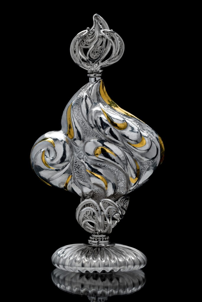 Femina, mirror-formed Eastern repoussé and keum boo bottle with 3D filigree and micro-formed stopper and stand, 2026 Sterling, fin silver, 24k gold; 4 x 2.75 x 1.75 in; photo by Pat Vasquez-Cunningham