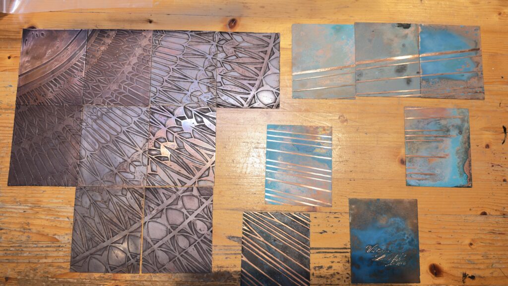Some of the 66 tiles for the etched panel that will go on another wall. My studio assist McKenna and I are in the process of removing the patinas off the raised areas.
